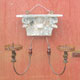 A small double candle wall sconce with genuine carved wood and embossed steel strips