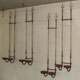 Two pairs of simple wrought iron candle wall sconces made using original antique iron railings and embossed steel strips